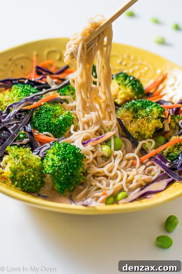 Close-up of coconut curry noodle bowl featuring colorful vegetables and rich sauce