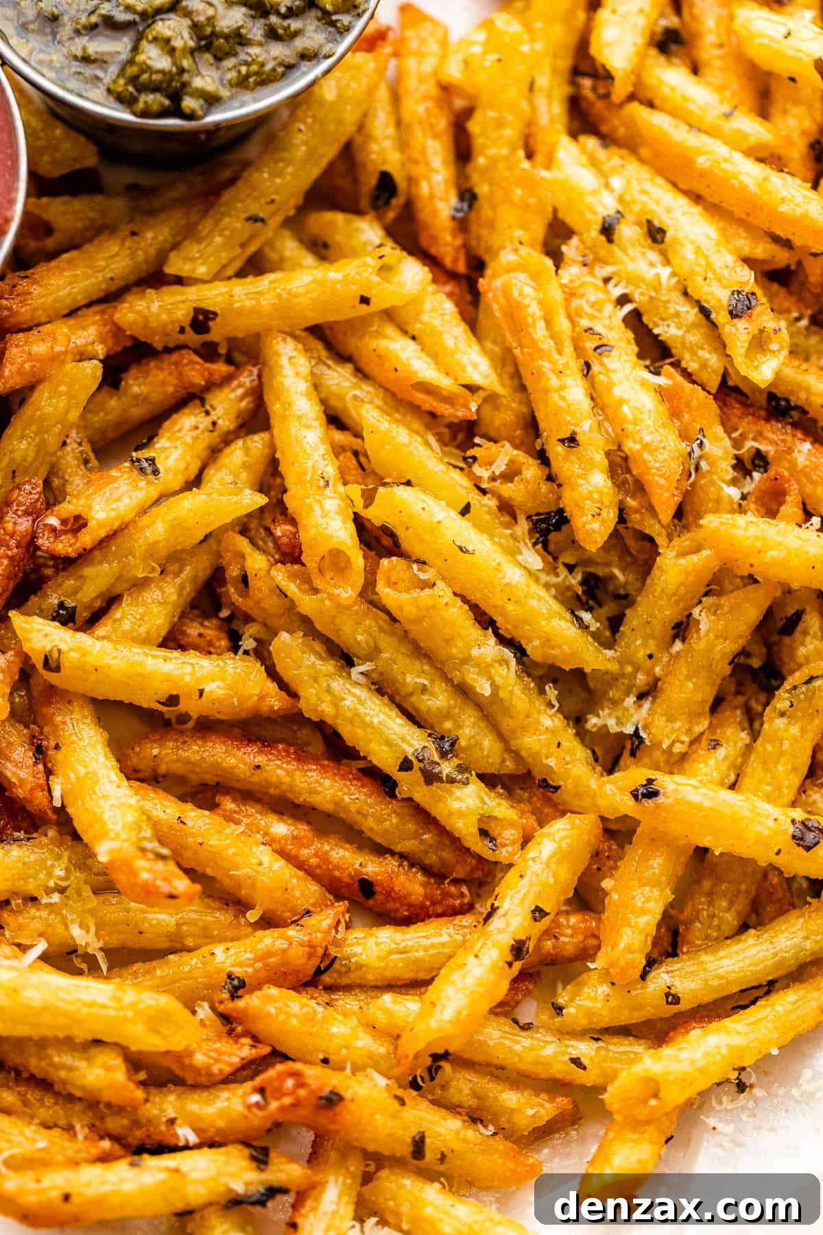 close up of baked pasta chips served with basil pesto