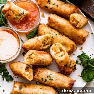 A plate of golden veggie spring rolls with dipping sauce, showcasing their crispy texture.