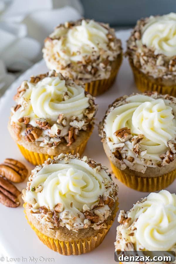 Close-up of a single carrot cake cupcake, showcasing its fluffy texture and rich cream cheese frosting.