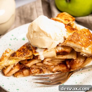 A perfectly baked slice of apple pie, topped with a scoop of vanilla ice cream, ready to be served.