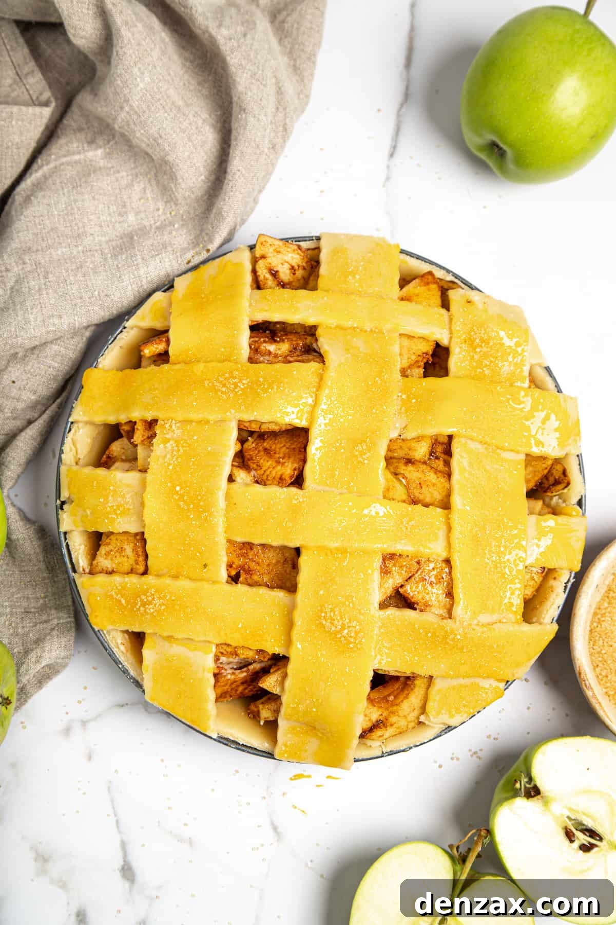 An unbaked apple pie featuring a beautifully woven lattice top, ready for the oven.