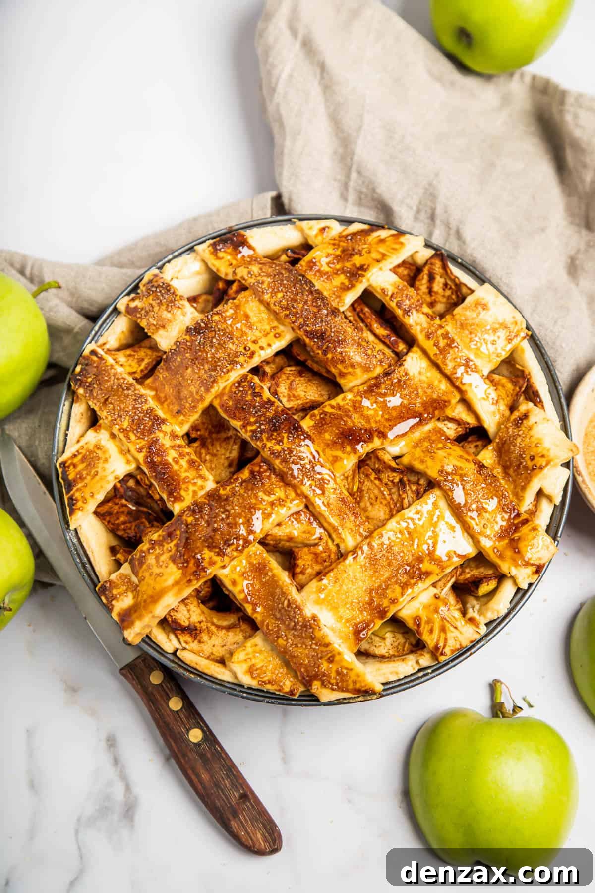 A perfectly baked homemade apple pie with a golden-brown lattice top, cooling on a wire rack.