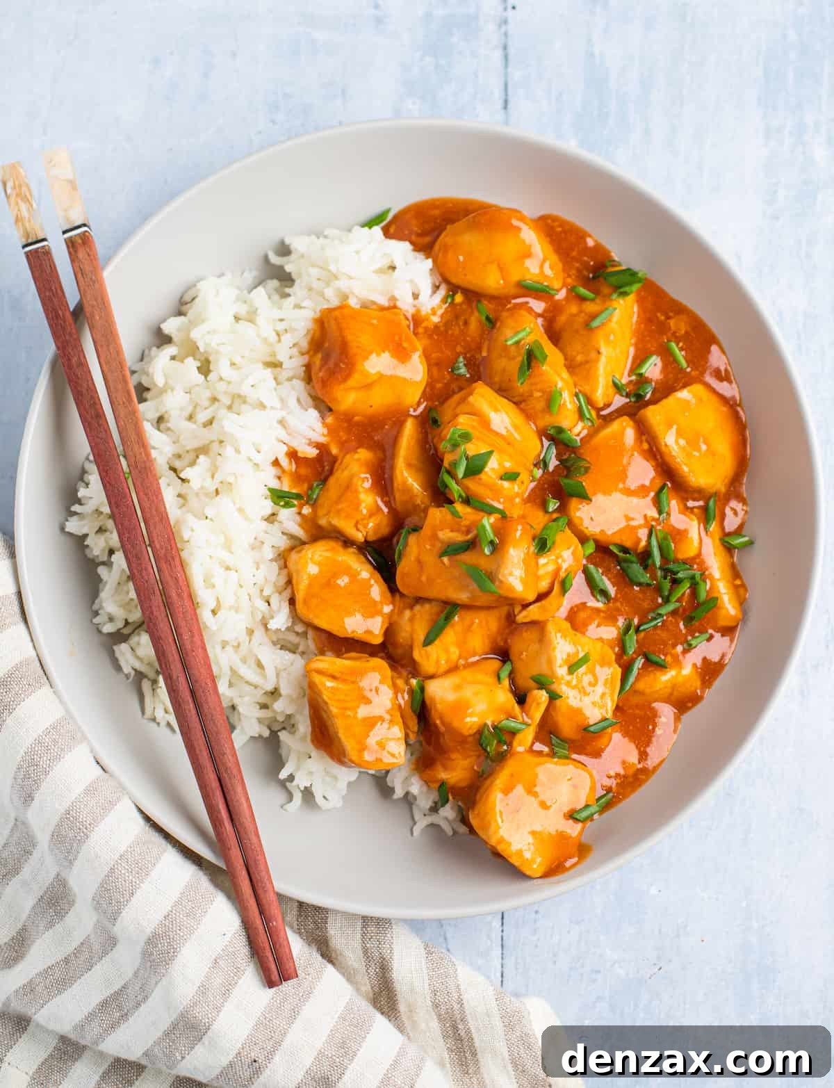 Centered overhead shot of orange chicken with rice.