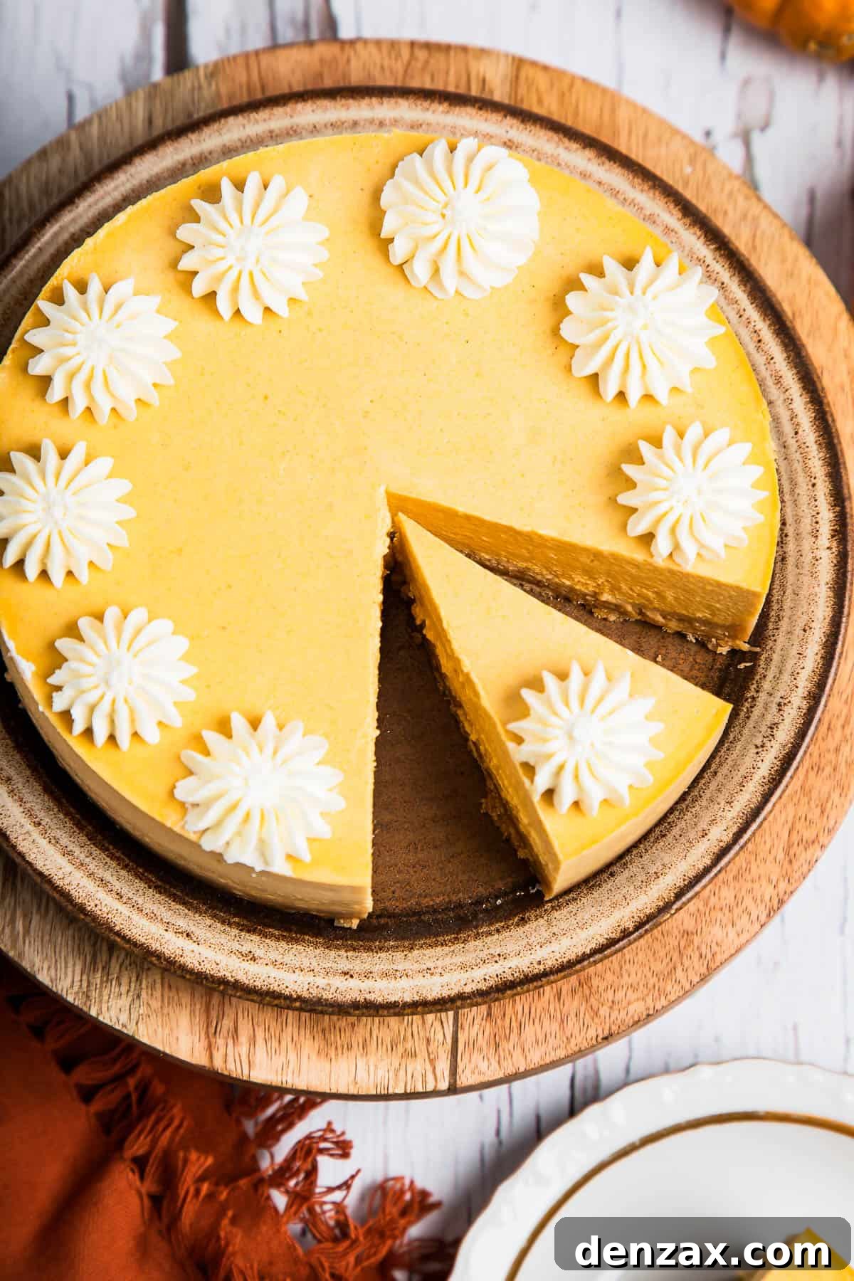 Pumpkin cheesecake decorated with whipped cream.