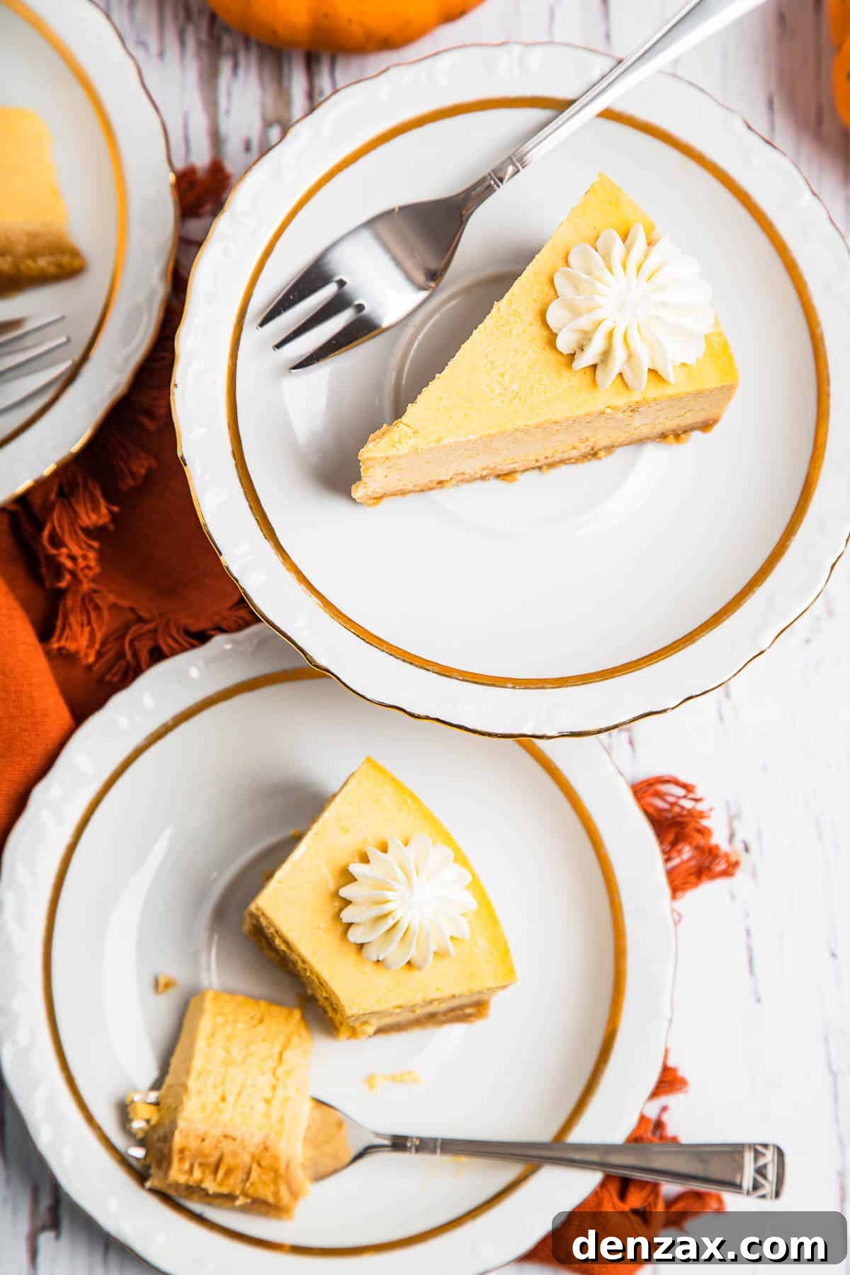 overhead shot of two plates with slices of pumpkin cheesecake