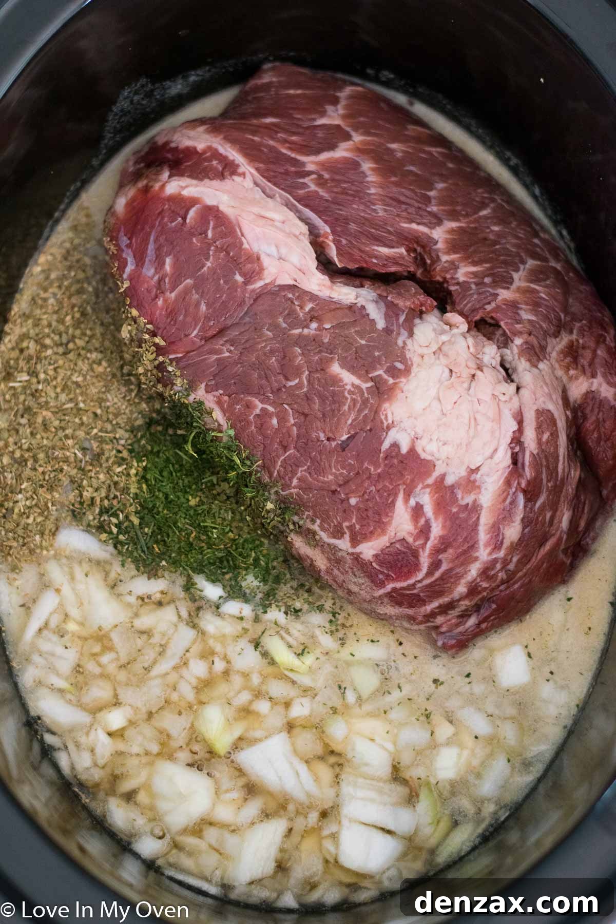 Ingredients for slow cooker Italian beef, including chuck roast, spices, and pepperoncini, ready for assembly.