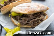 Slow Cooker Italian Beef Sandwiches on a platter with dipping broth.