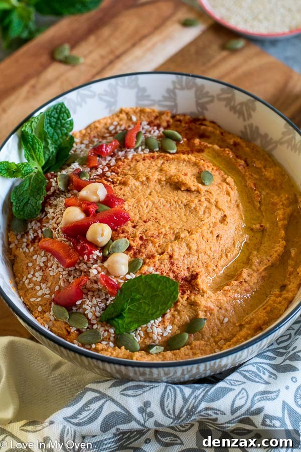 Overhead shot of spicy roasted red pepper hummus with crackers and vegetables