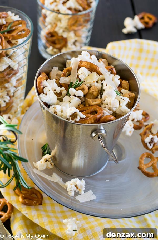 Serving bowl filled with Parmesan Rosemary Popcorn and mixed nuts