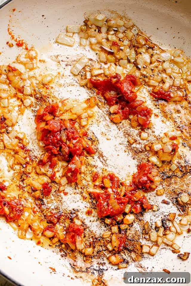 Sauté onions in bacon fat frying onions in a white skillet