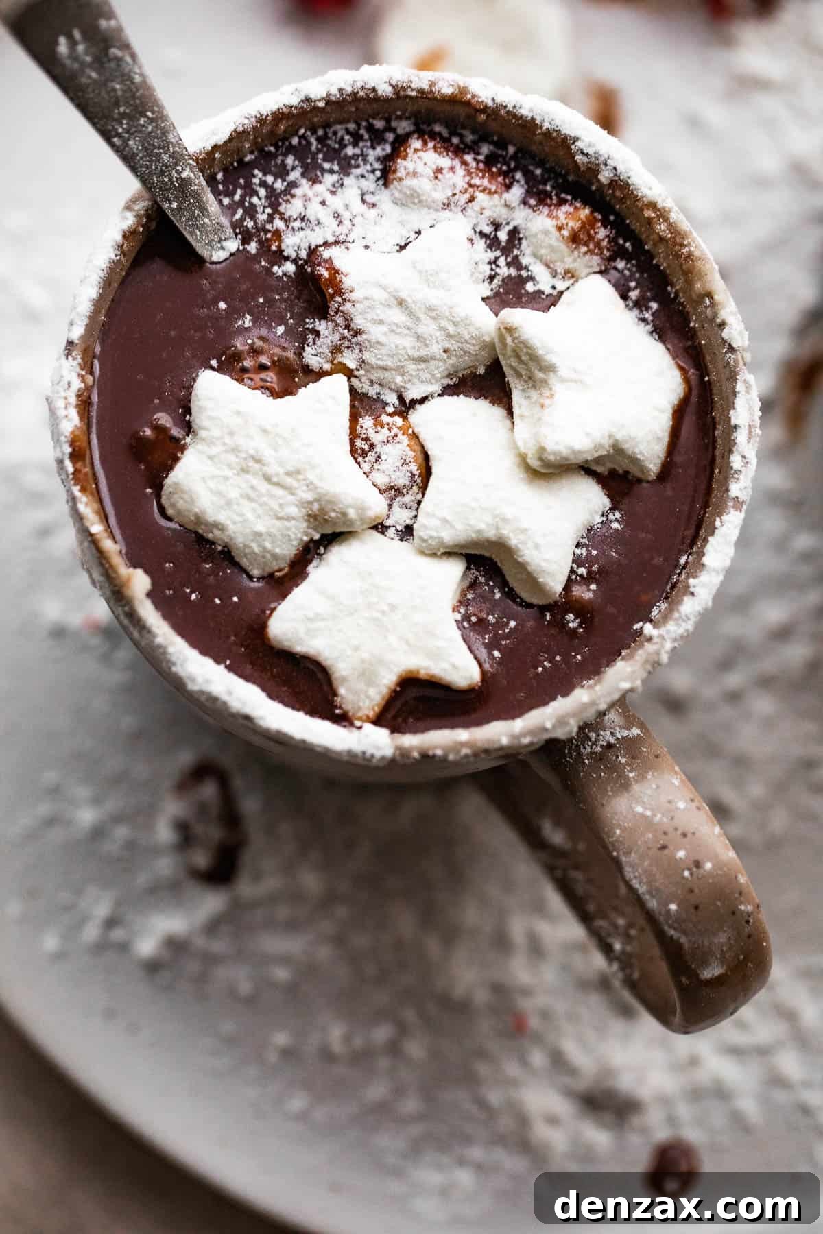 overhead shot of hot chocolate in a brown mug and topped with star shaped marshmallows