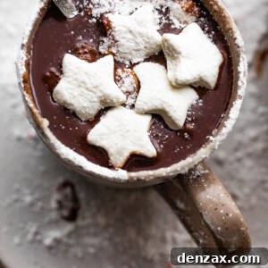 overhead shot of hot chocolate in a brown mug and topped with star shaped marshmallows