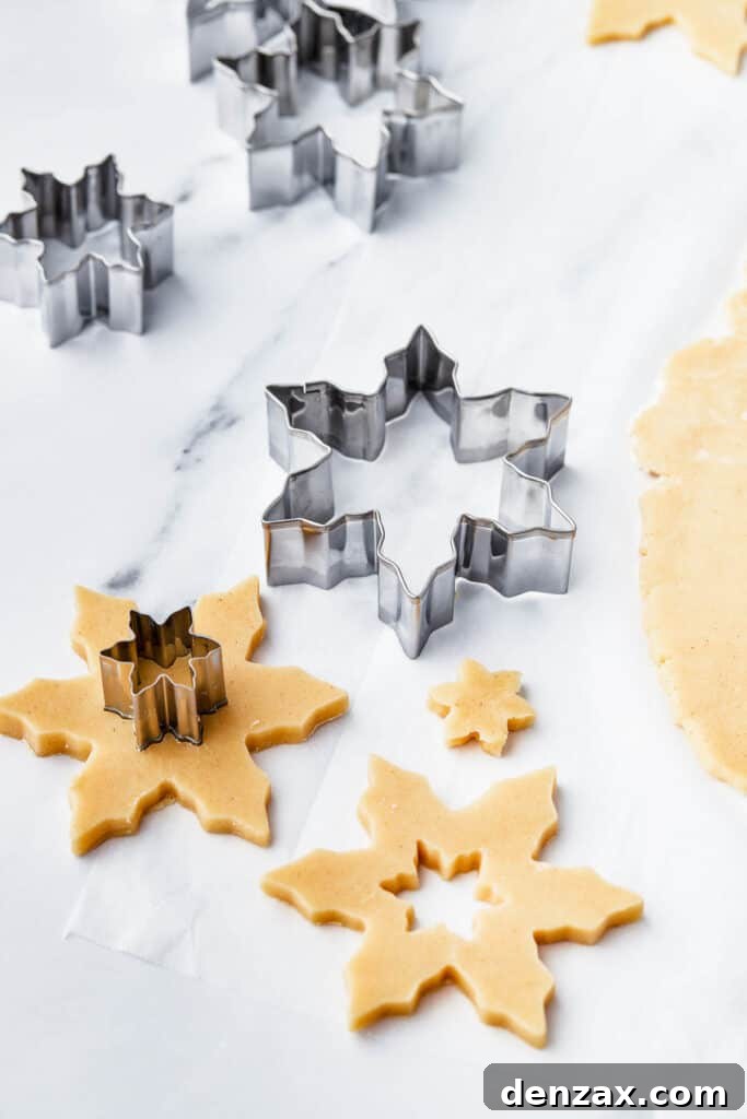 Cut out snowflake-shaped cookies on a work surface.