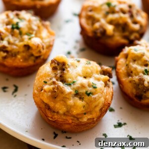 sausage breakfast cups arranged on a light plate and garnished with chopped parsley