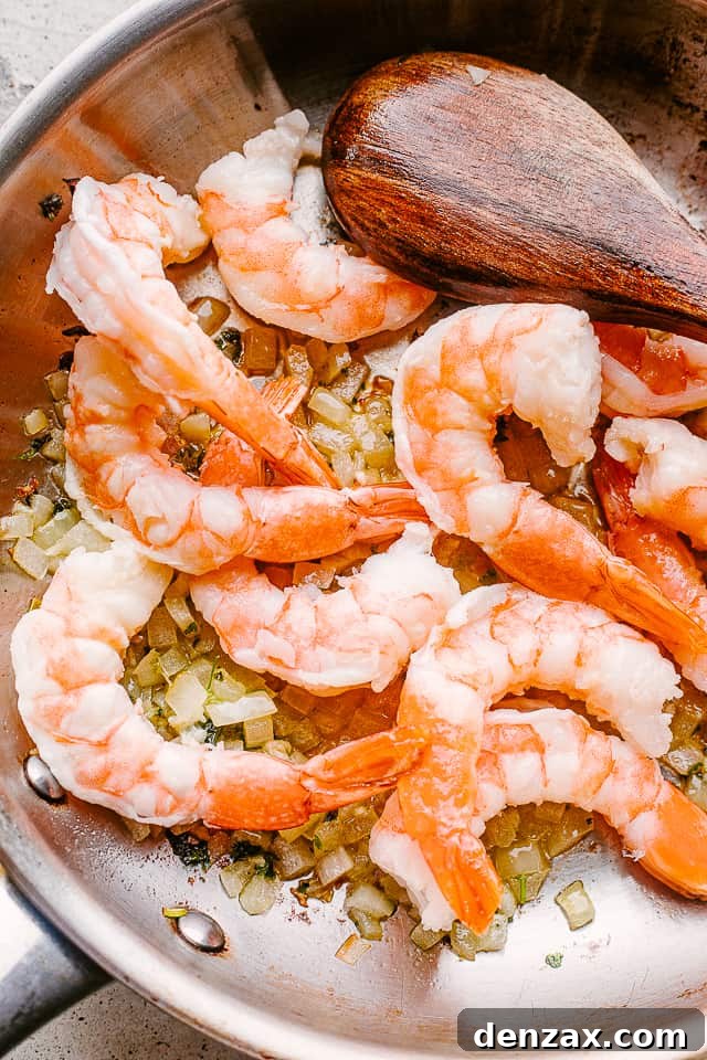 Shrimp sauteing in a pan with garlic.
