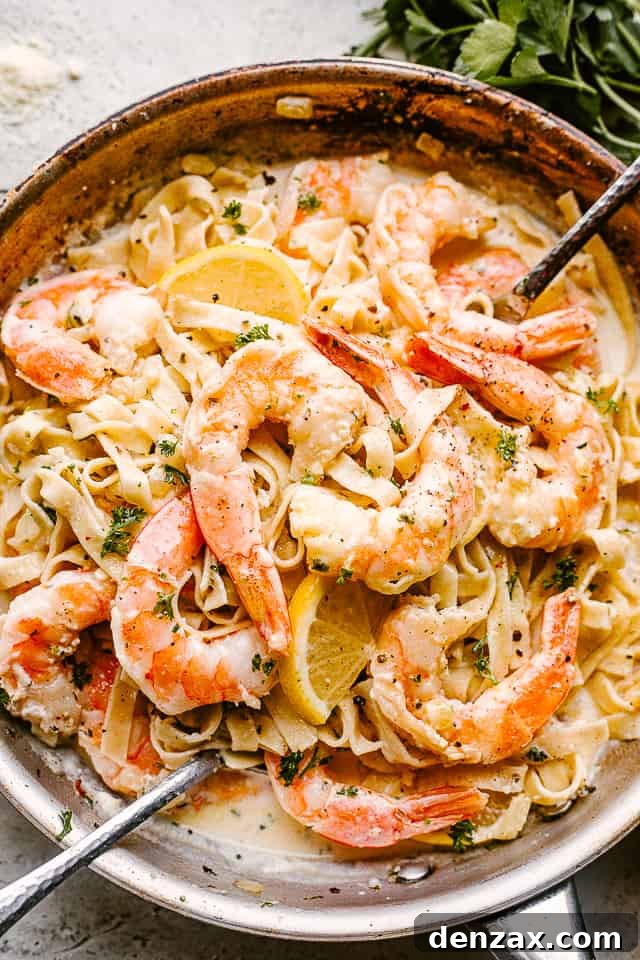Creamy Shrimp Alfredo Pasta with serving spoons ready to be eaten