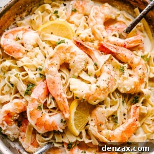 Creamy Shrimp Alfredo Pasta with serving spoons ready to be eaten