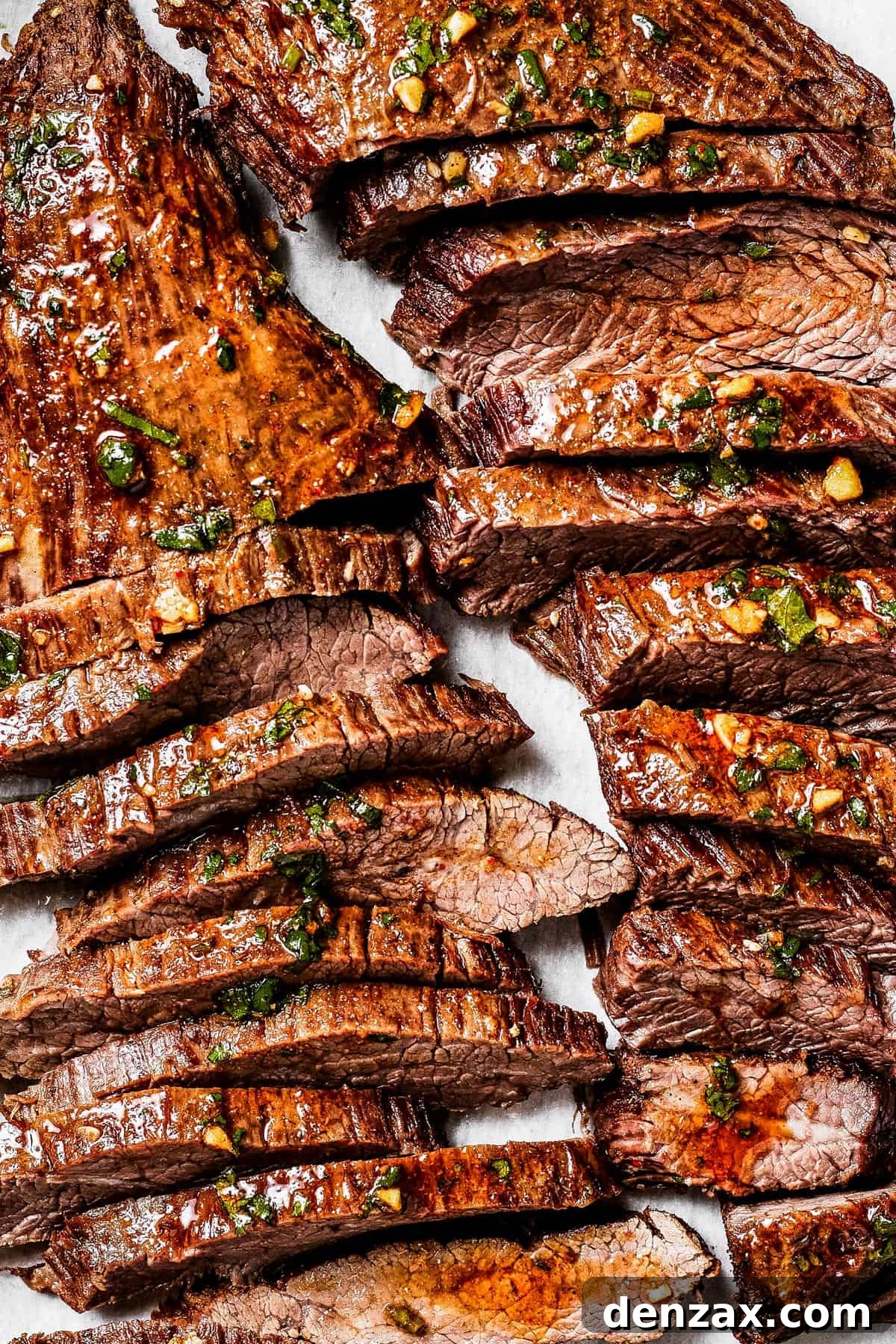 Sliced cooked steak on a cutting board.