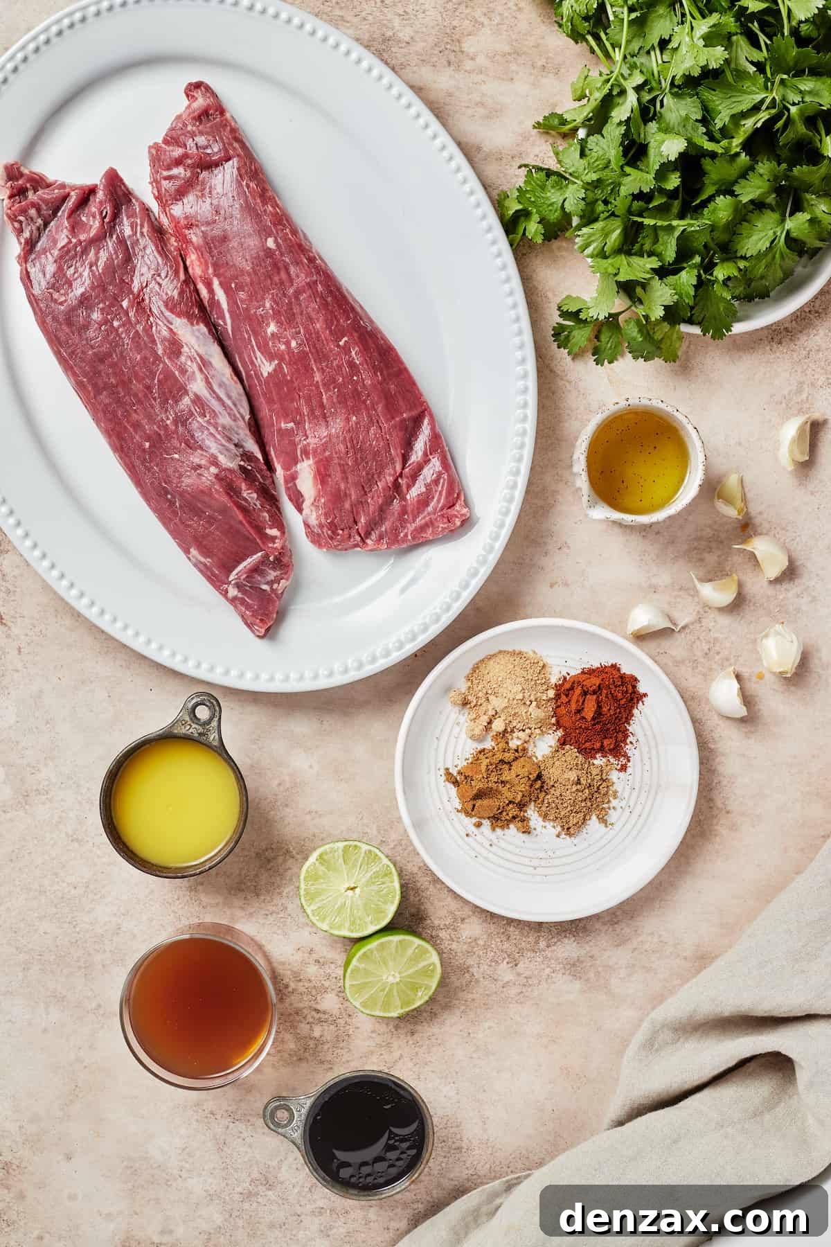 From top left: Flank steak pieces, fresh cilantro, avocado oil, garlic, spices, lime halves, tamari sauce, beef broth, orange juice.
