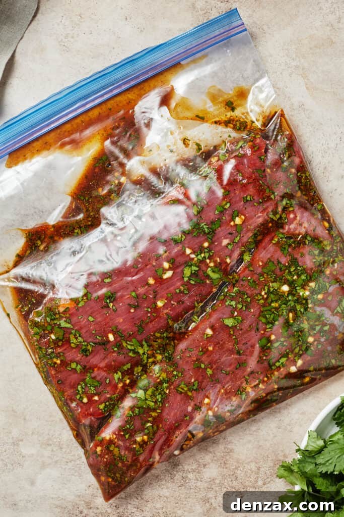 A zip-top bag with flank steak and marinade inside.