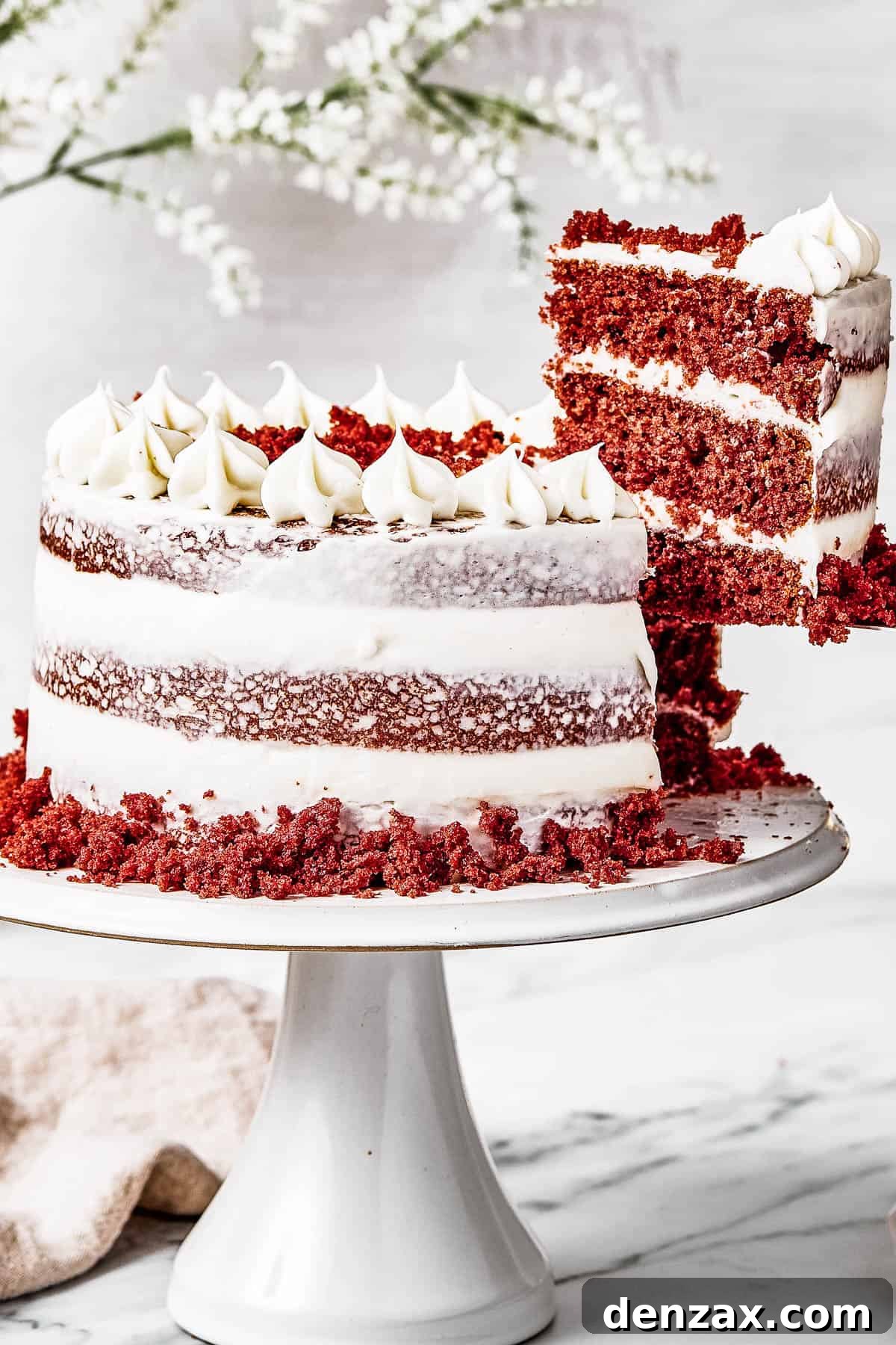 A woman's hand is lifting a slice of cake on a serving utensil.