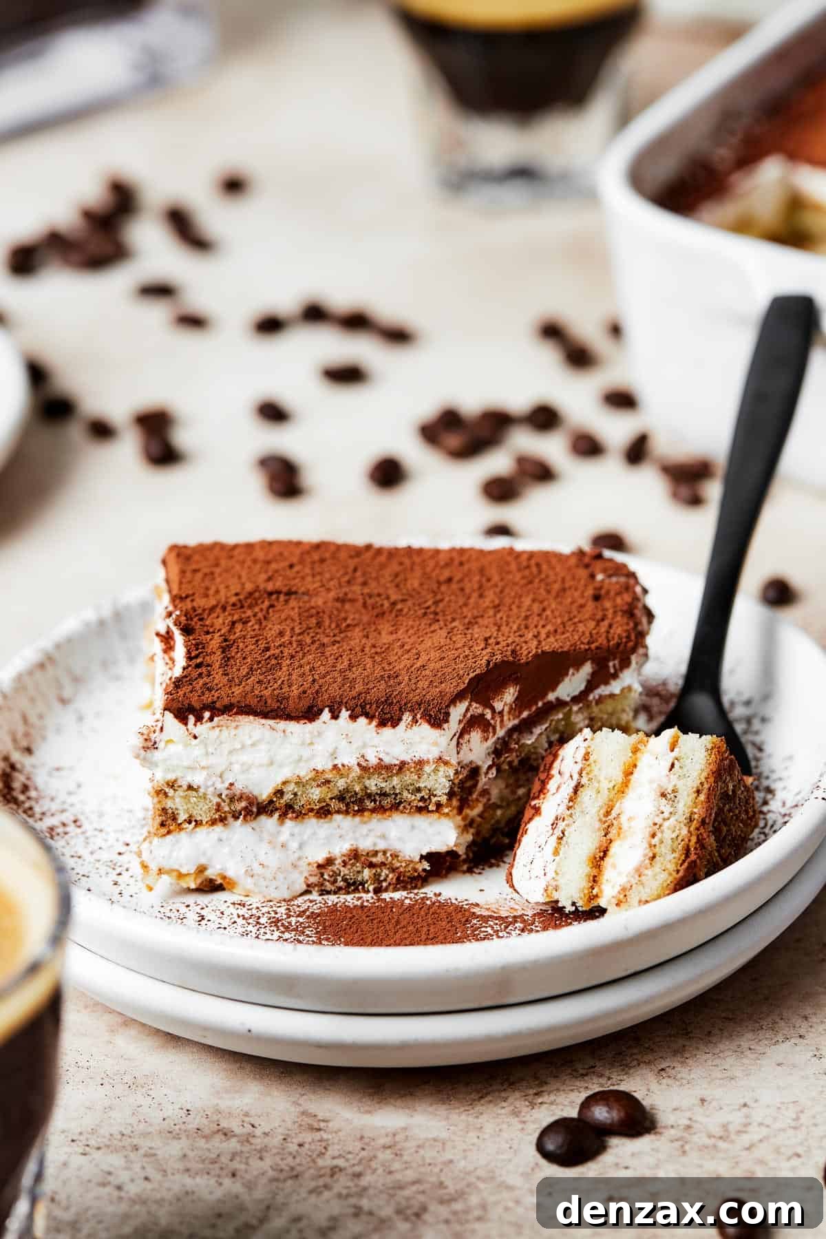 A serving of layered, chilled dessert with a forkful lying nearby on the plate.