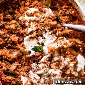 overhead shot of Cabbage Roll Casserole in a white baking dish, and the casserole is smothered with sour cream on top.