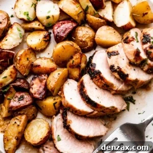 overhead shot of a serving plate with sliced roast pork tenderloin served with colored baby potatoes