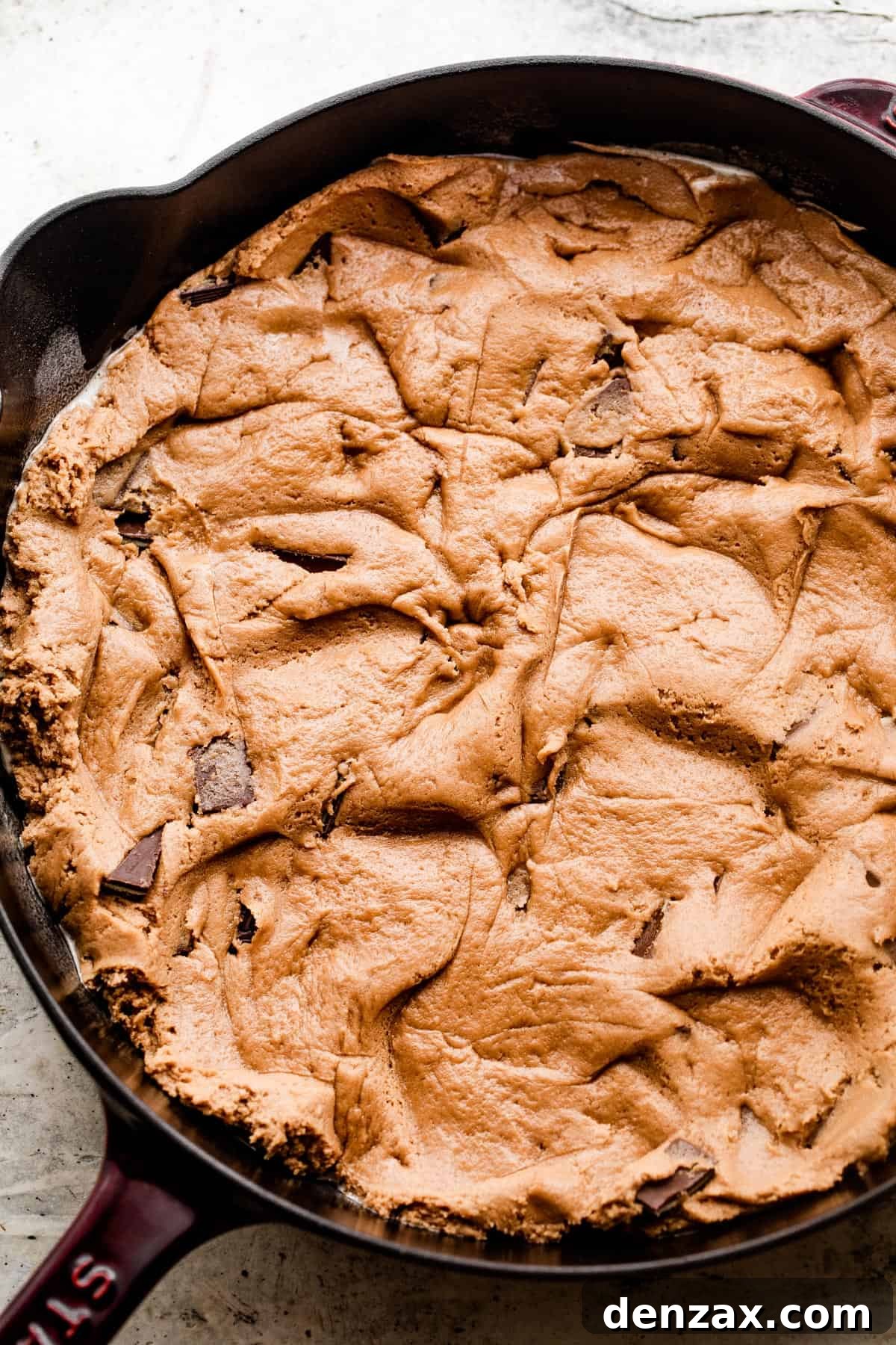 raw cookie dough spread out into a skillet.