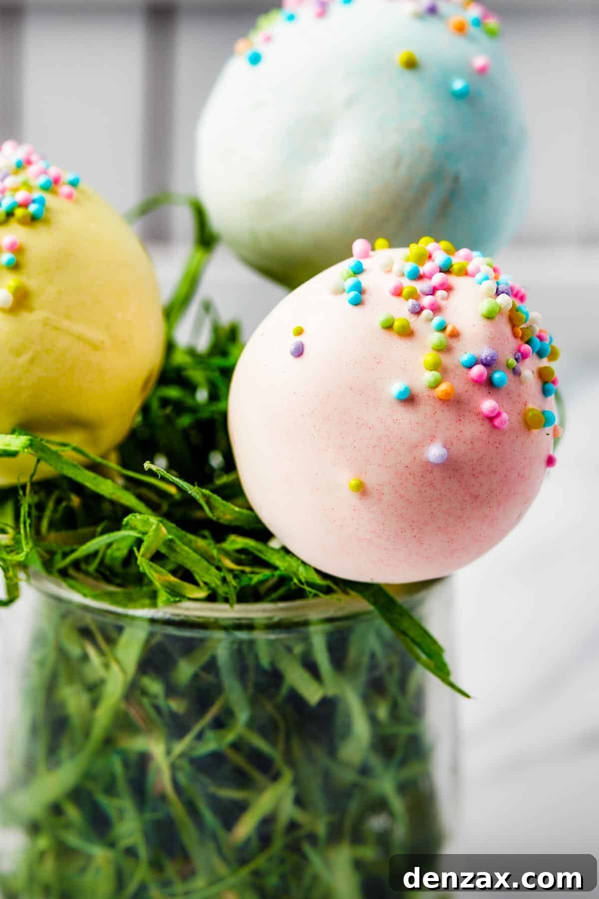 Pastel lollipops in a white basket filled with Easter grass.