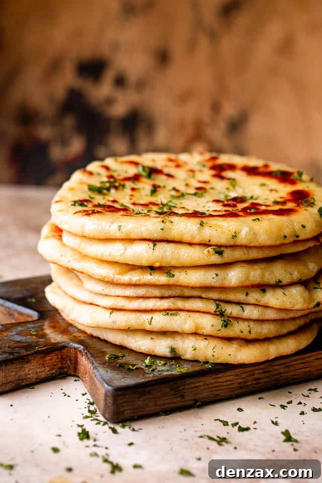 Stack of homemade flatbread on a wooden board.