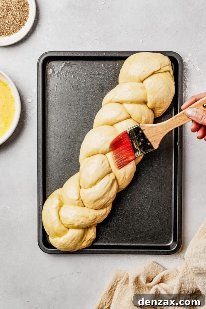 Classic Homemade Challah Recipe: Soft, Fluffy Braided Bread 7 Unbaked egg bread on a sheet pan, being brushed with egg wash.