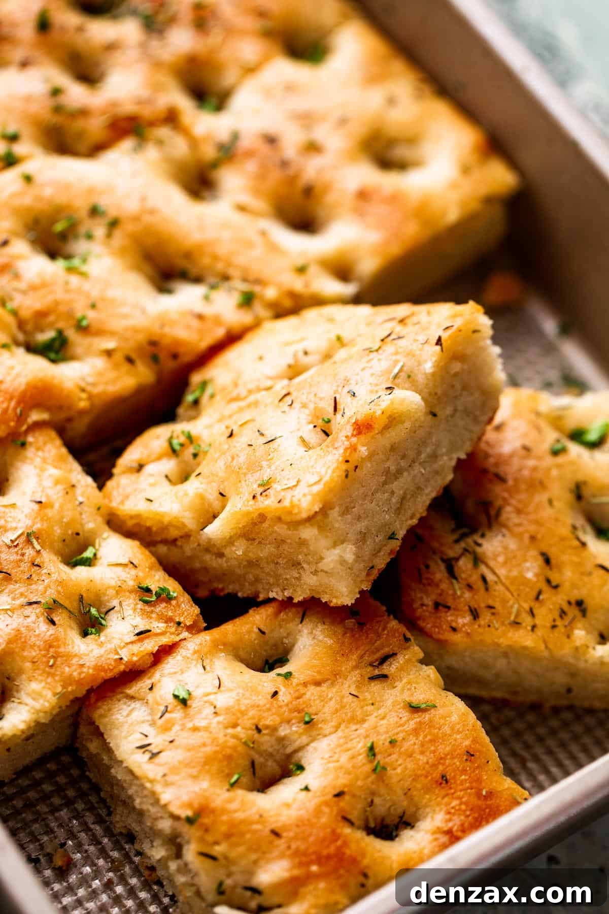 A large pan-sized loaf of focaccia, with one 4 squares cut away.