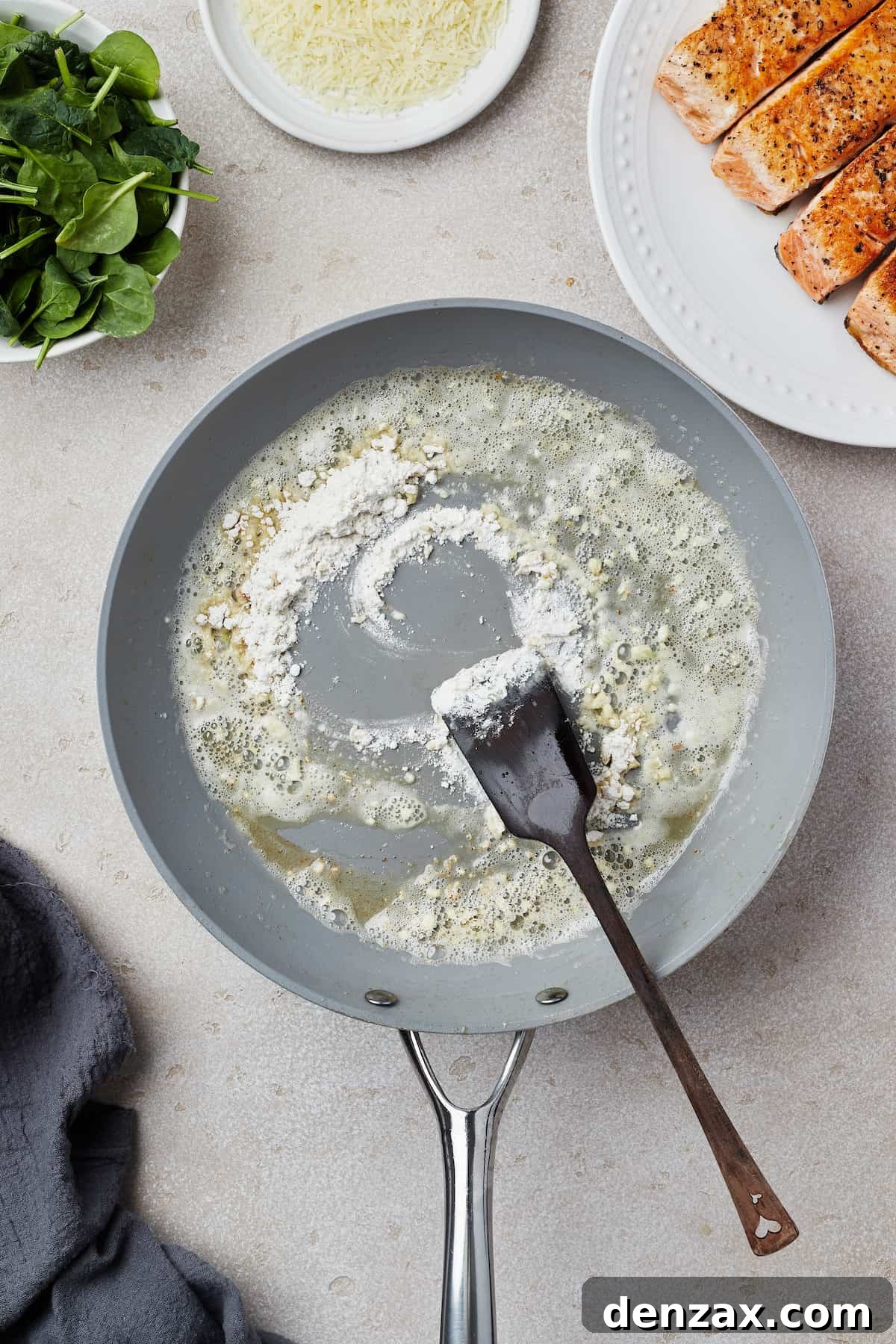 A skillet with melted butter, garlic, and flour cooking in it.