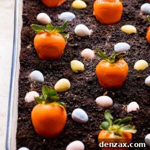 Oreo Dirt Cake topped with chocolate covered strawberries and chocolate egg candy