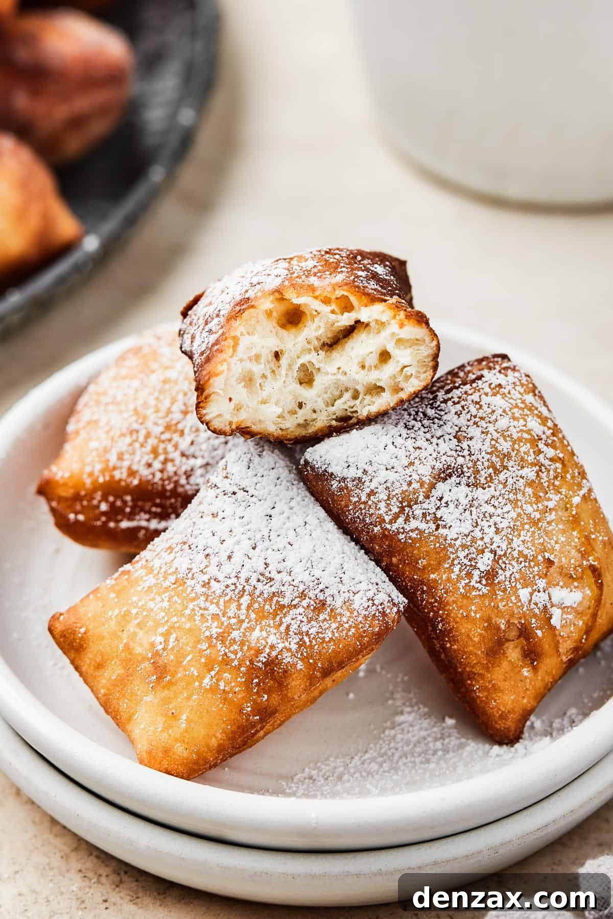 Square donuts on a plate, one broken in half to show the fluffy interior.