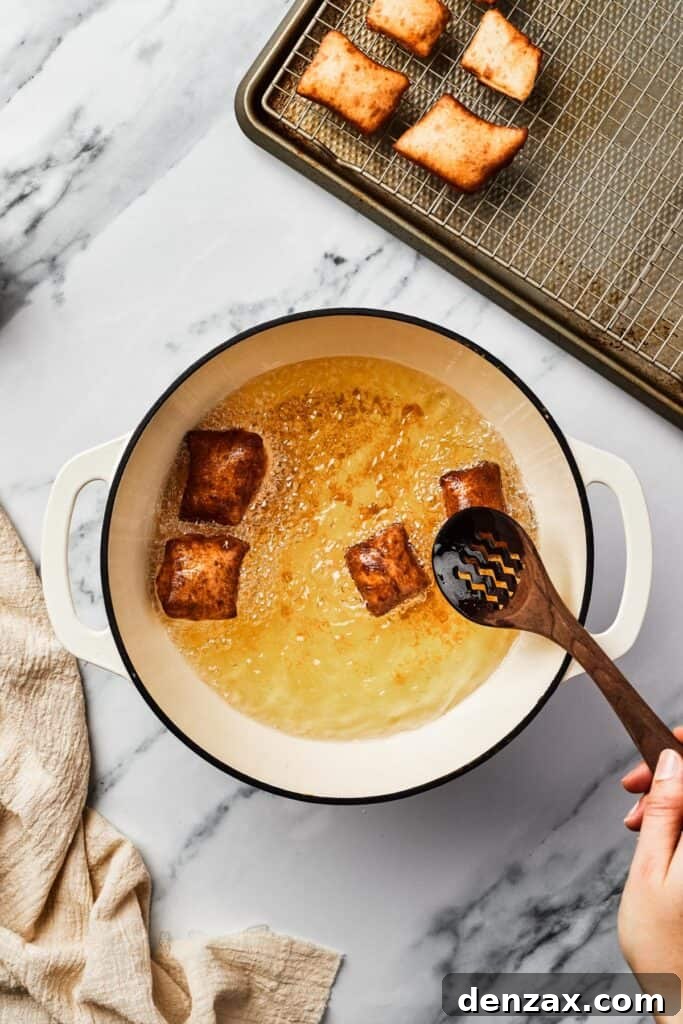 Browned, fried squares of dough in a Dutch oven partially filled with hot oil.