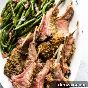 overhead shot of breadcrumb coated lamb chops arranged on a serving platter with a side of green beans placed above the chops.