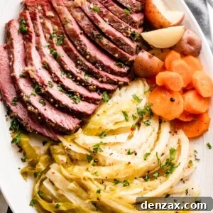 sliced instant pot corned beef, cabbage, carrots, and potatoes arranged on an oval serving platter.