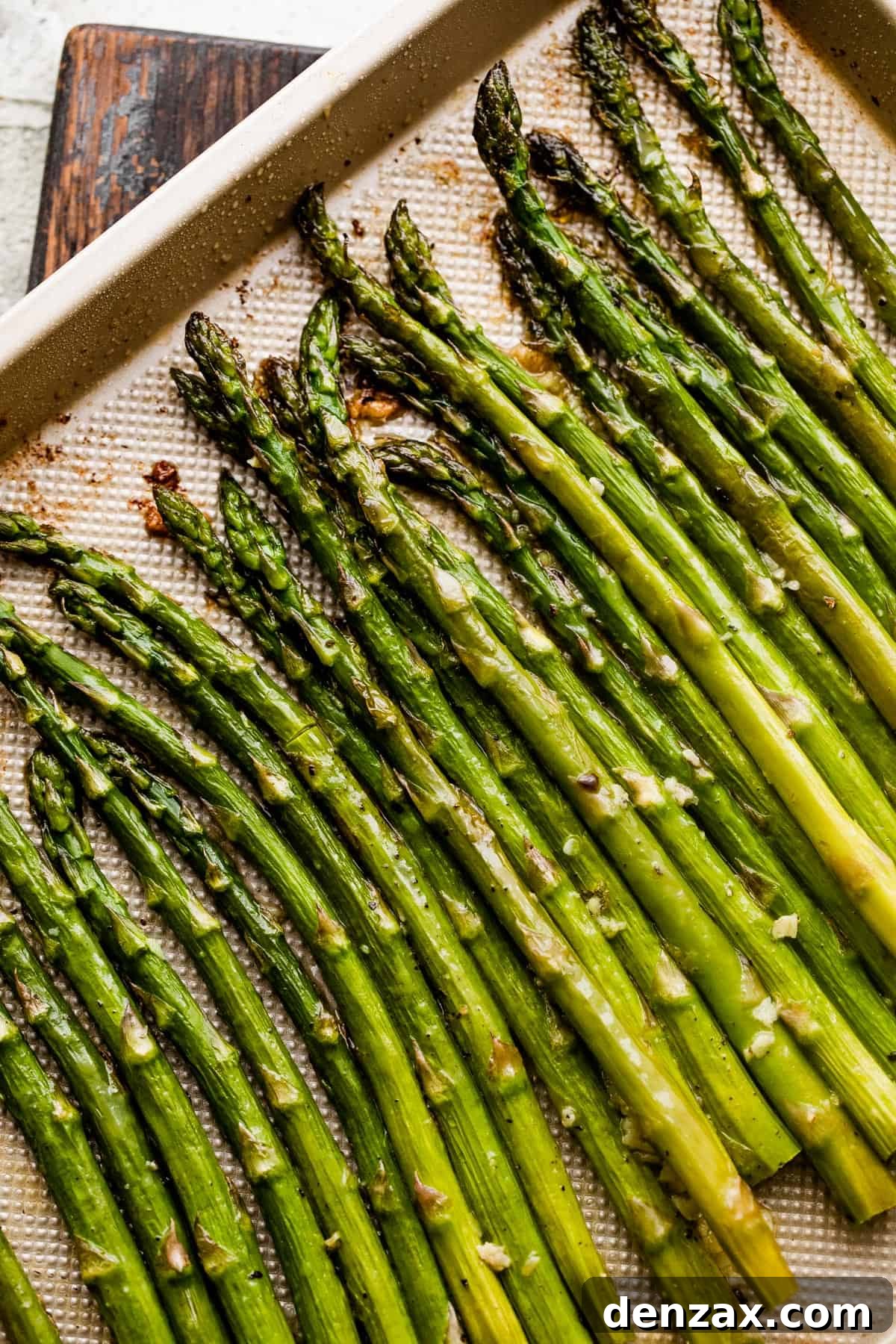 asparagus spears arranged on a gold-colored baking sheet.