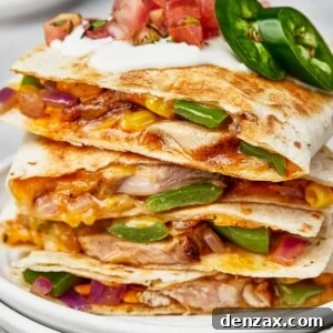 Chicken quesadillas stacked on a plate, viewed from the side to show texture.