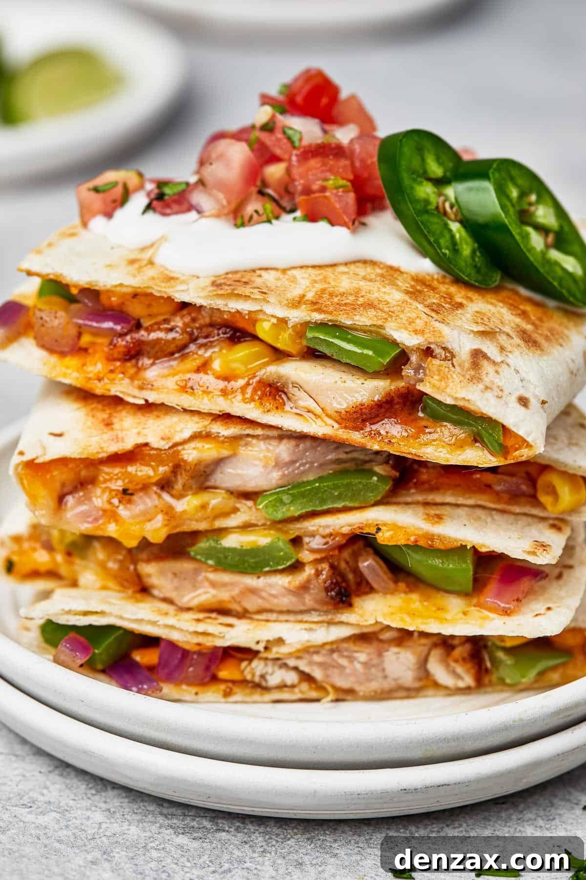 Chicken quesadillas stacked on a plate, viewed from the side to show texture.
