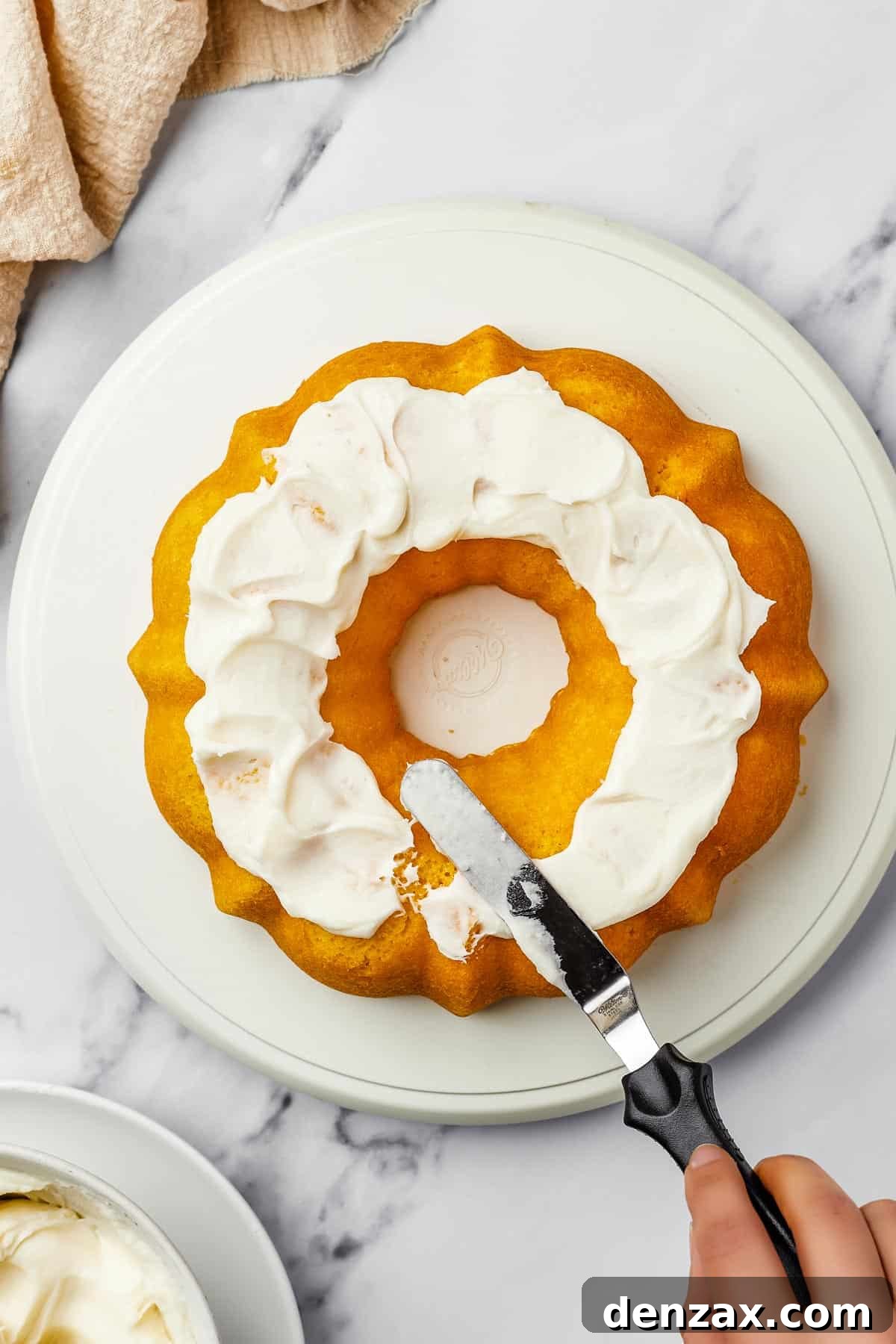 Overhead shot of a bundt cake iced with thick, creamy frosting.