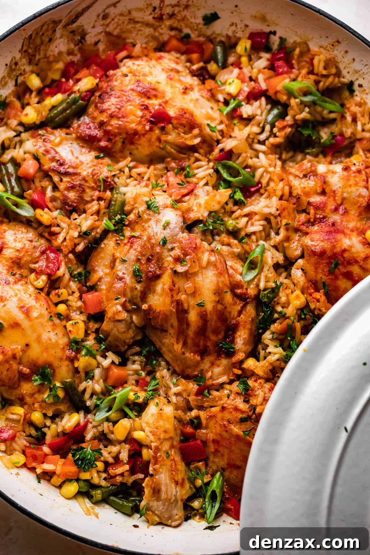 overhead shot of a round casserole dish with ranch chicken thighs, rice, and vegetables.