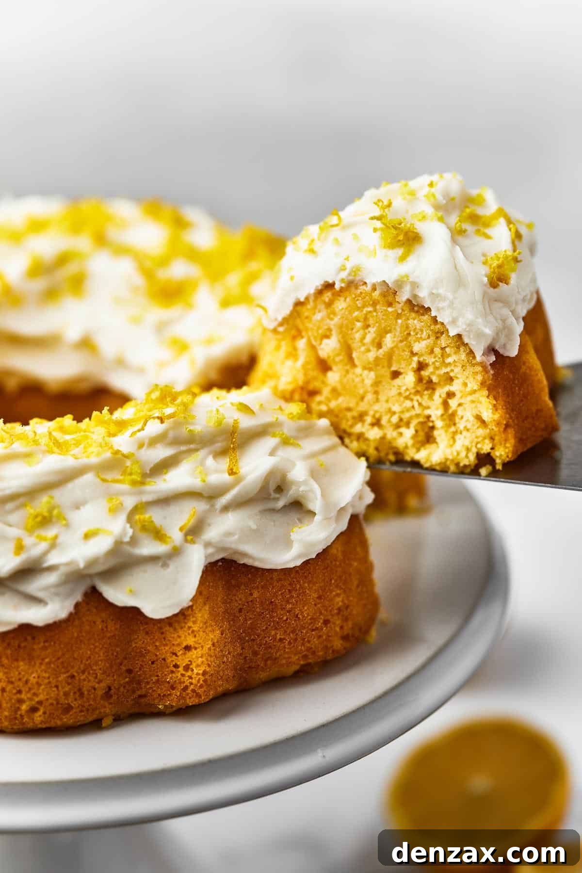 A Bundt cake on a platter, with one slice being removed on a cake server.