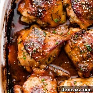 overhead shot of a baking dish with six honey garlic baked chicken thighs garnished with sesame seeds.