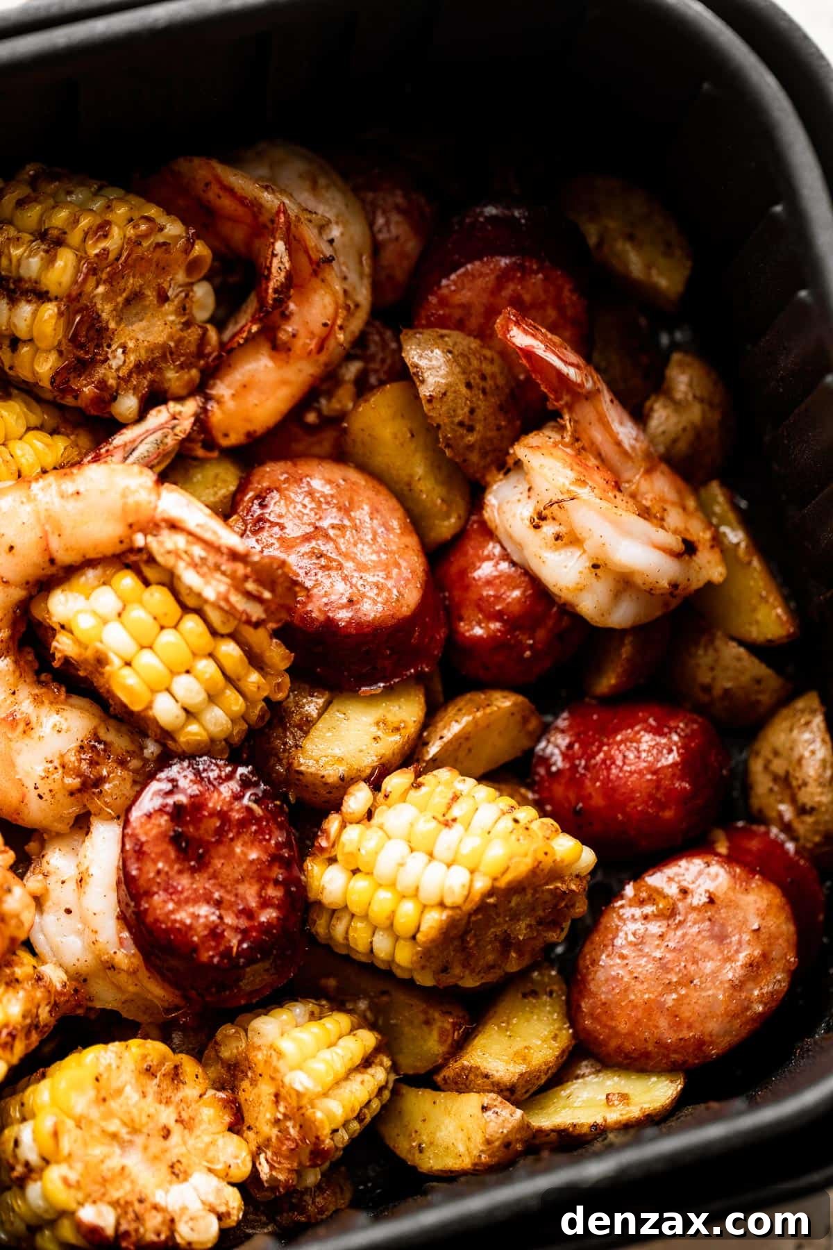 close up shot of corn on the cob rounds, andouille sausage rounds, and shrimp