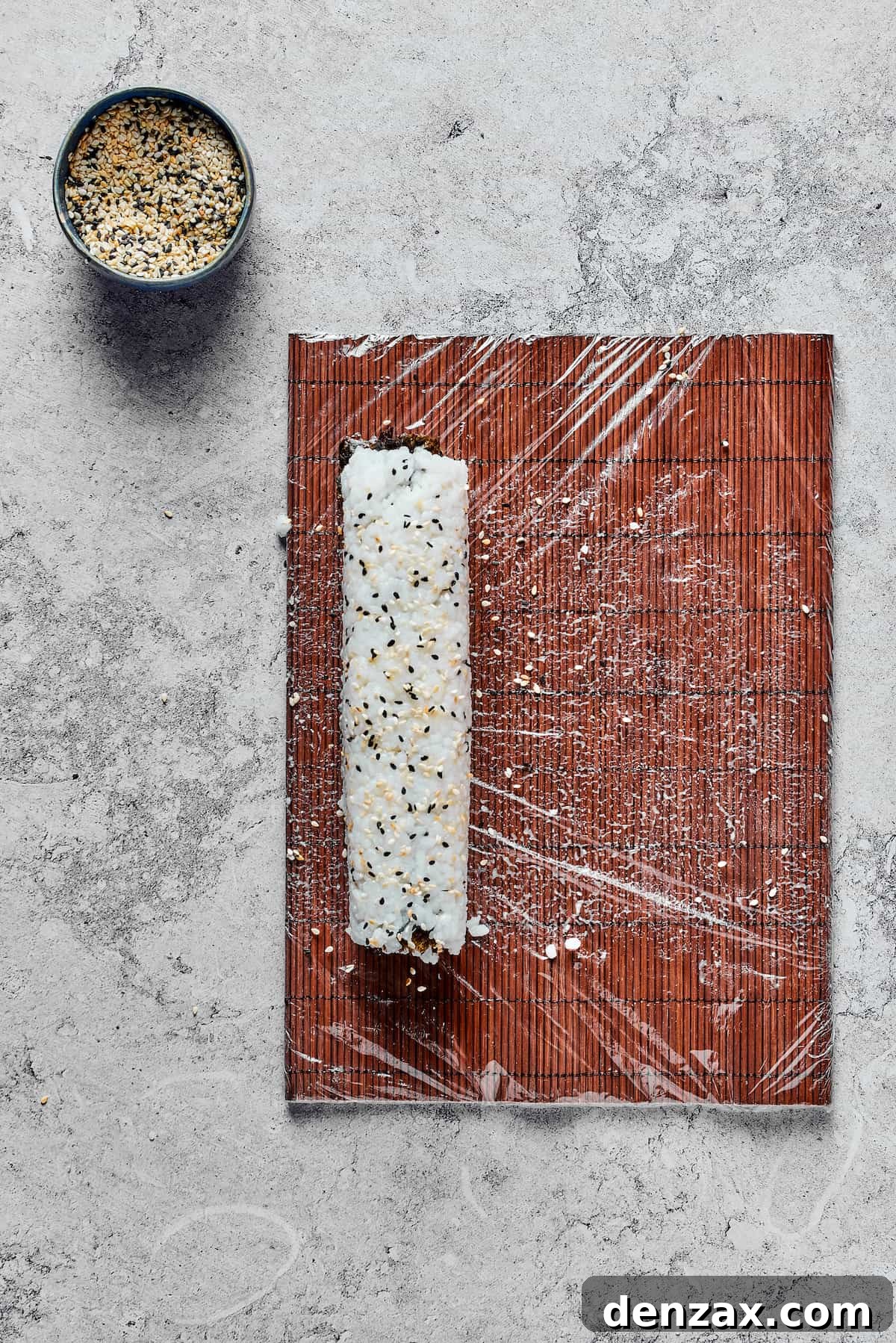 A roll of sushi on a bamboo mat.