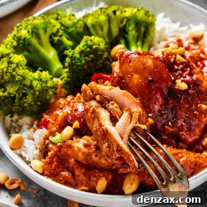A close-up shot of a chicken thigh cooked in peanut sauce, with a fork pulling away a bite.